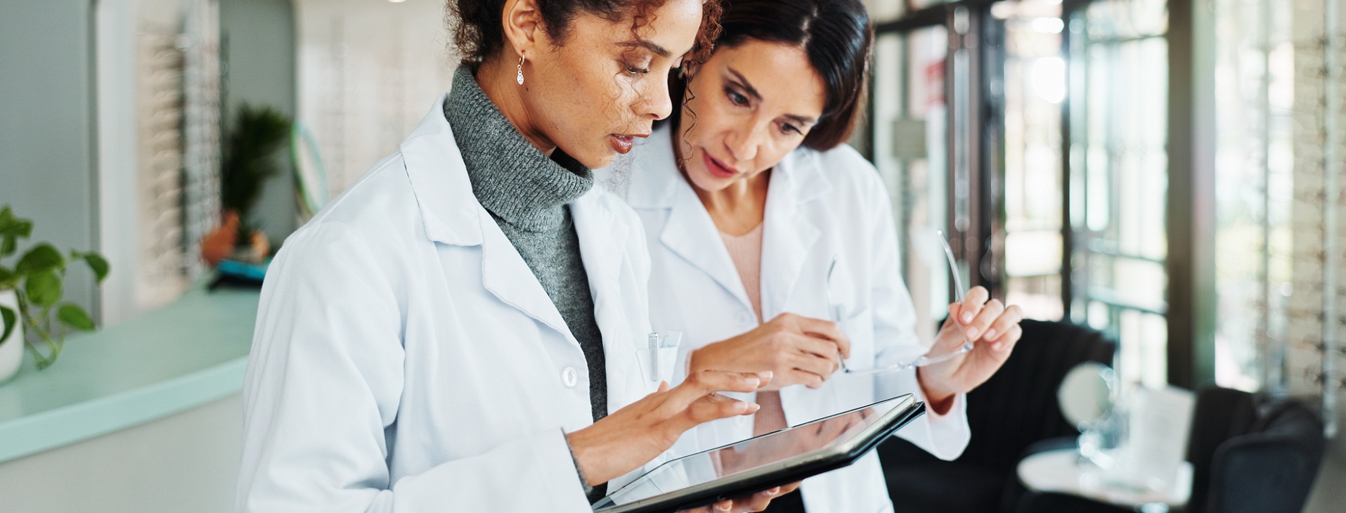 Optometrists checking information on tablet on an eyecare practice