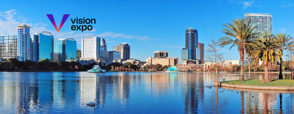 Orlando skyline with modern high-rise buildings reflecting on a lake under a bright blue sky, with the Vision Expo logo in the upper left corner.